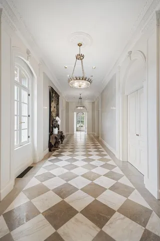 a view of a hallway with windows and chandelier