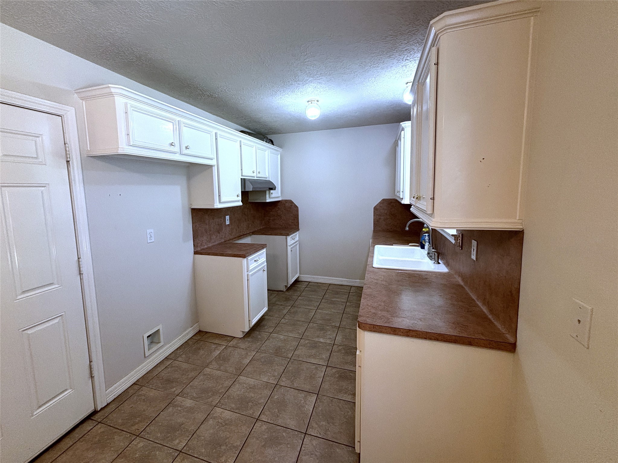 9329 Intervale Street Houston, TX 77075 - Photo 4 of 11 a kitchen with a sink and a refrigerator
