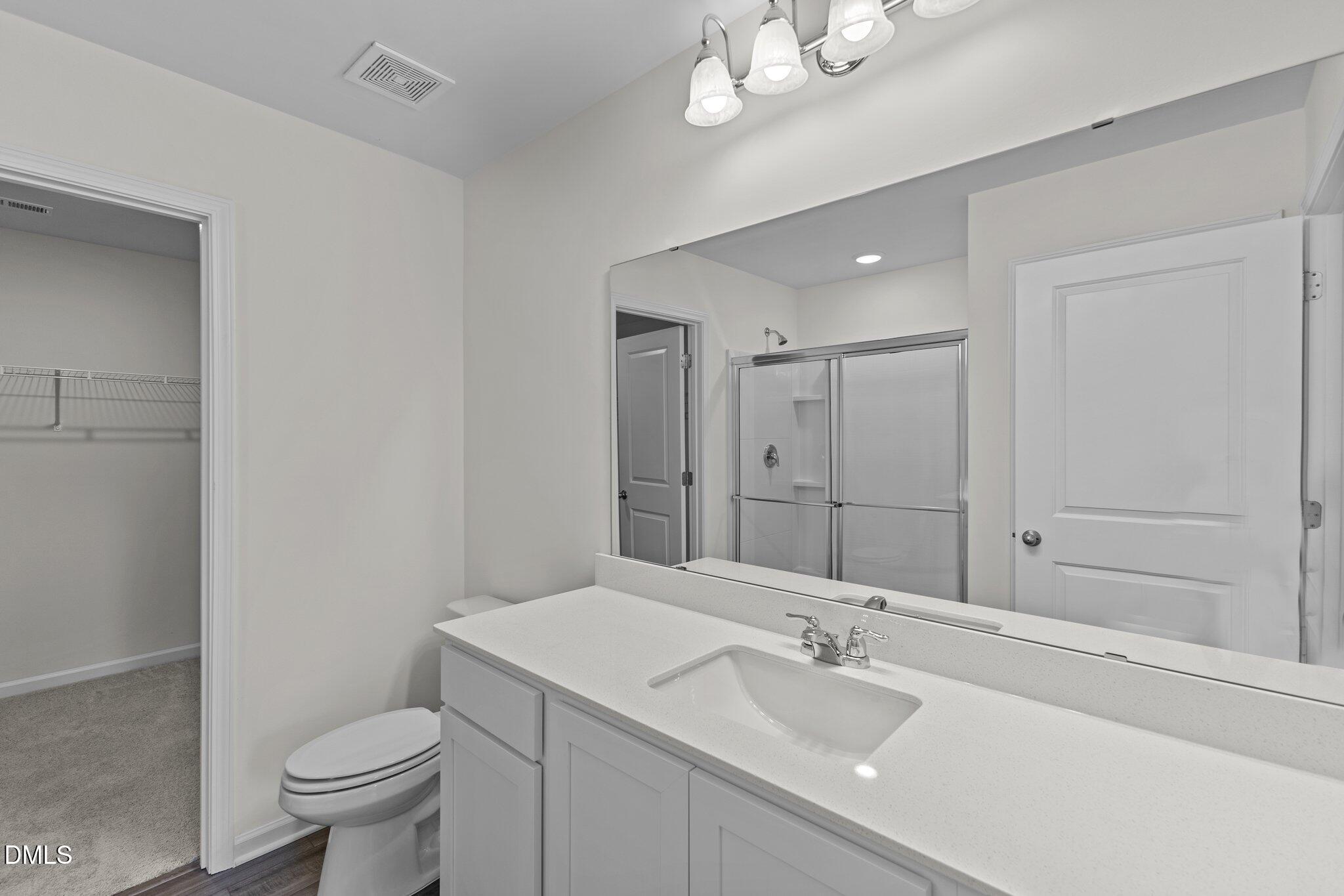 987 Bombardier Alley Spring Hope, NC 27882 - Photo 19 of 23 a bathroom with a sink a toilet a mirror and shower