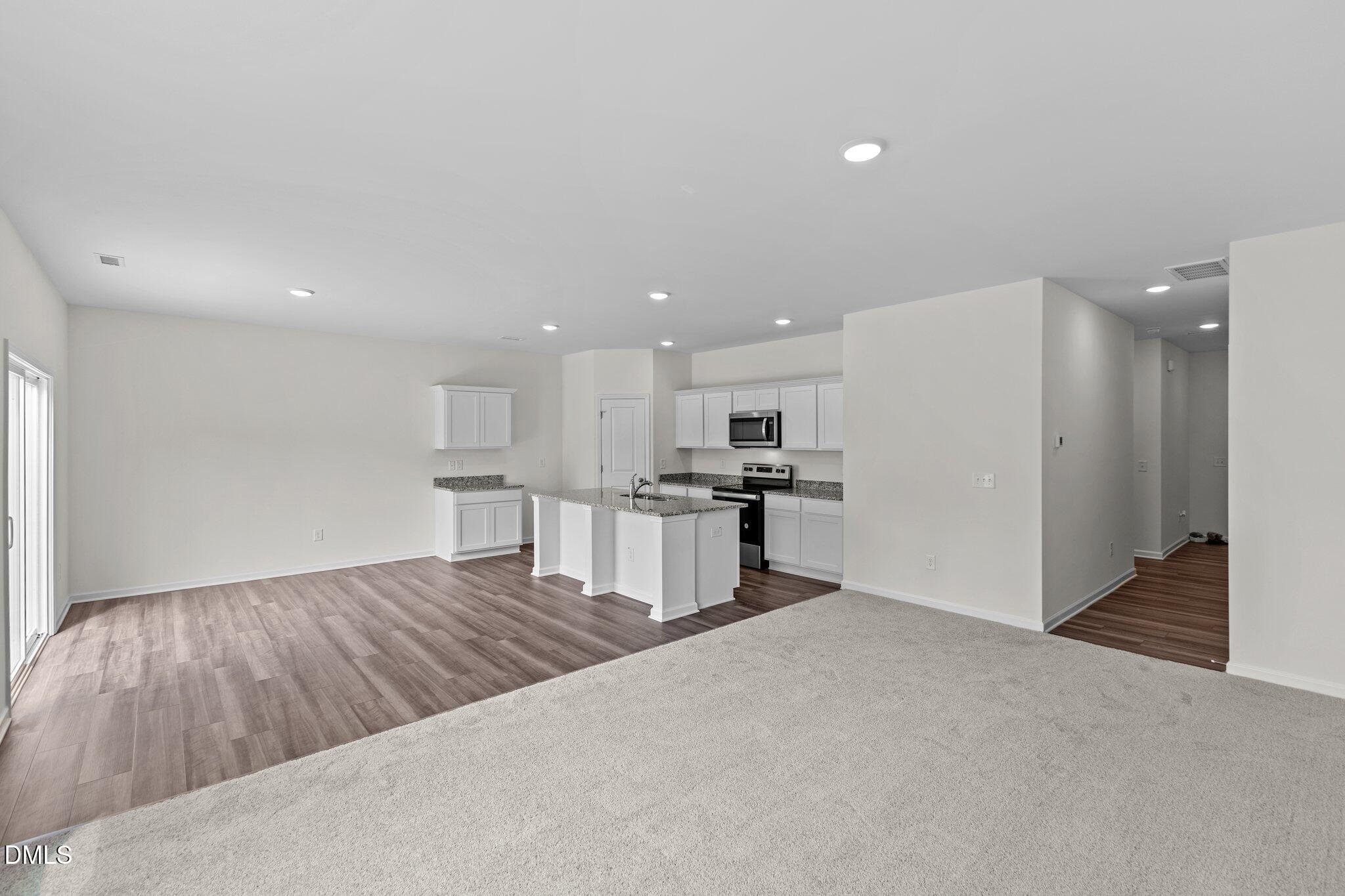 987 Bombardier Alley Spring Hope, NC 27882 - Photo 6 of 23 a kitchen with kitchen island white cabinets and refrigerator