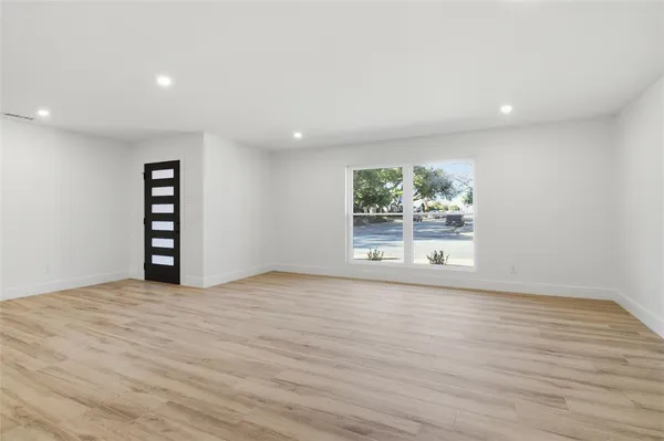 a view of a big room with wooden floor and windows