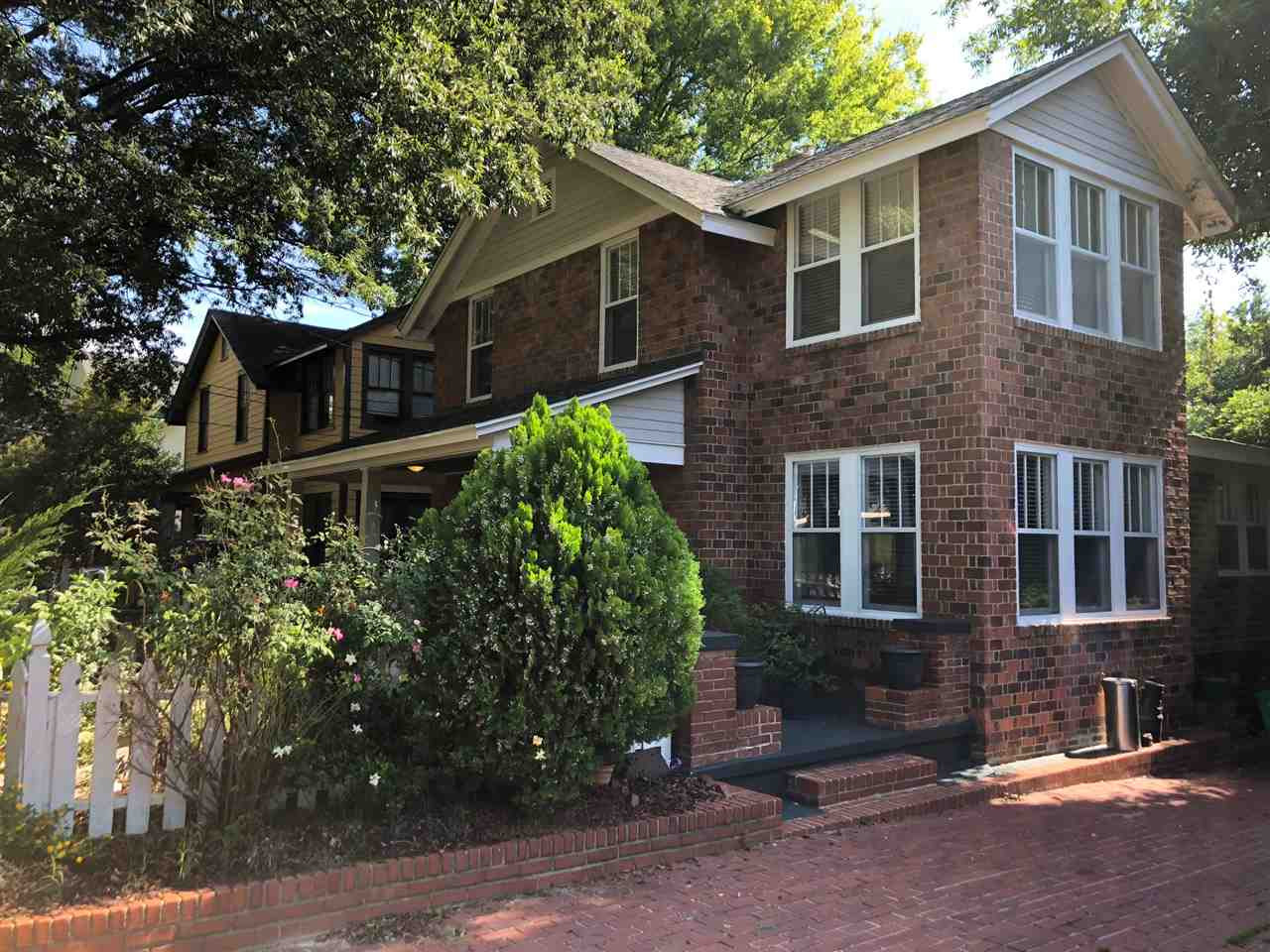 The 0.21 acre lot includes a brick paved driveway leading to a fenced back yard and an old “model T” sized utility building.