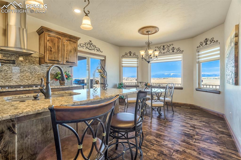 14335 Jones Road Peyton, CO 80831 - Photo 29 of 49 a kitchen with granite countertop a stove a sink a dining table and chairs