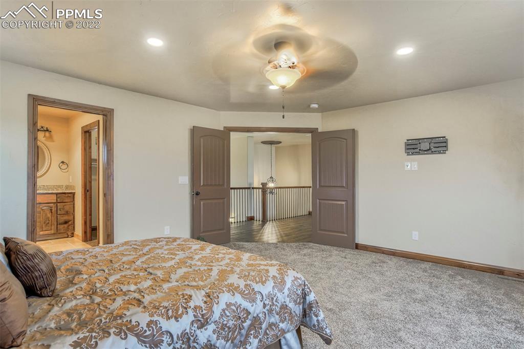 14335 Jones Road Peyton, CO 80831 - Photo 36 of 49 a bedroom with a bed and a chandelier