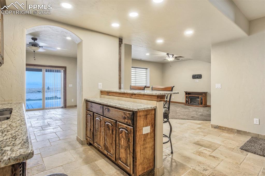 14335 Jones Road Peyton, CO 80831 - Photo 41 of 49 a spacious bathroom with a granite countertop sink a mirror and a vanity