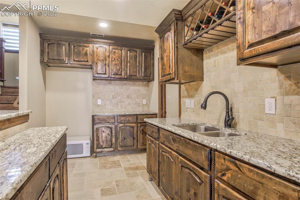 14335 Jones Road Peyton, CO 80831 - Photo 42 of 49 a kitchen with granite countertop a sink and cabinets