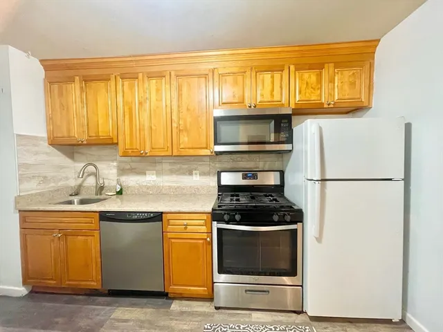 a kitchen with stainless steel appliances granite countertop a stove a microwave and a refrigerator