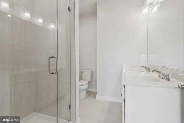 a bathroom with a granite countertop sink a toilet and shower