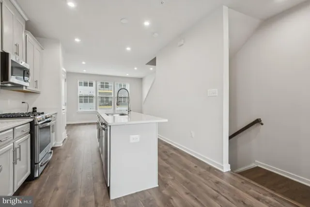 a kitchen with granite countertop a stove top oven and sink
