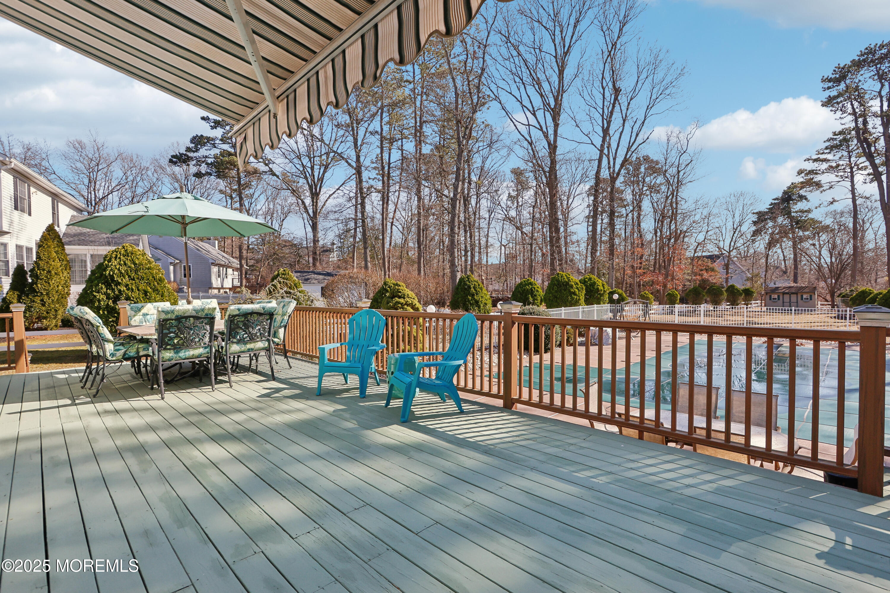 749 Rabbit Run Brick, NJ 08724 - Photo 26 of 43 a view of a roof deck with table and chairs under an umbrella with wooden floor