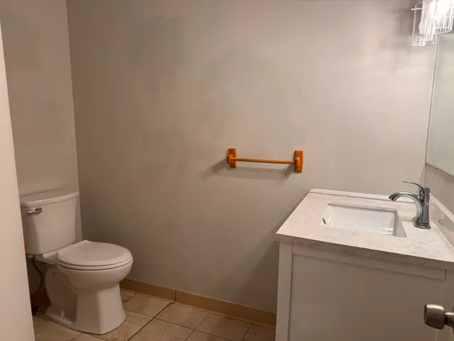 a bathroom with a toilet sink and mirror
