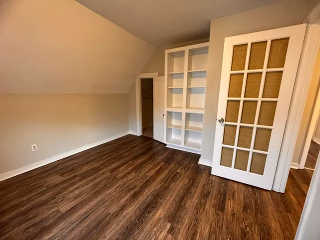 a view of empty room with wooden floor and windows