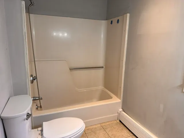a bathroom with a toilet and a bath tub