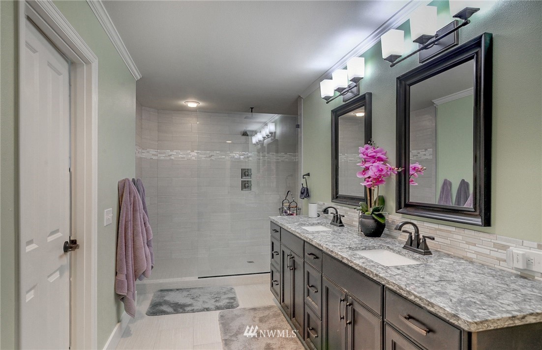 24204 21st Drive Southeast Bothell, WA 98021 - Photo 24 of 39 a bathroom with a granite countertop sink a large mirror and a shower