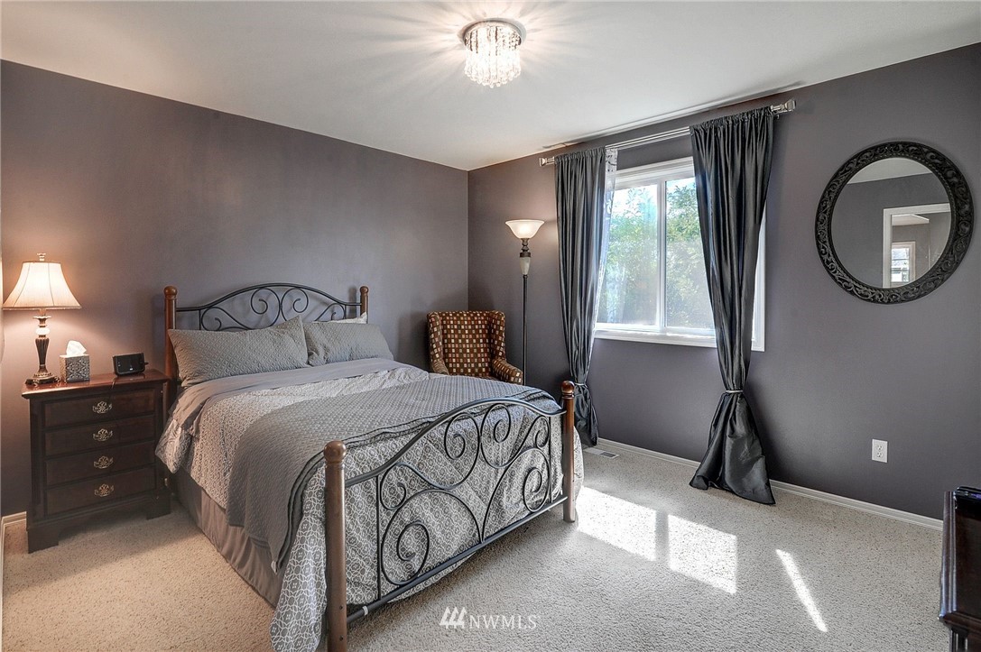 24204 21st Drive Southeast Bothell, WA 98021 - Photo 27 of 39 a bedroom with a bed and a chandelier