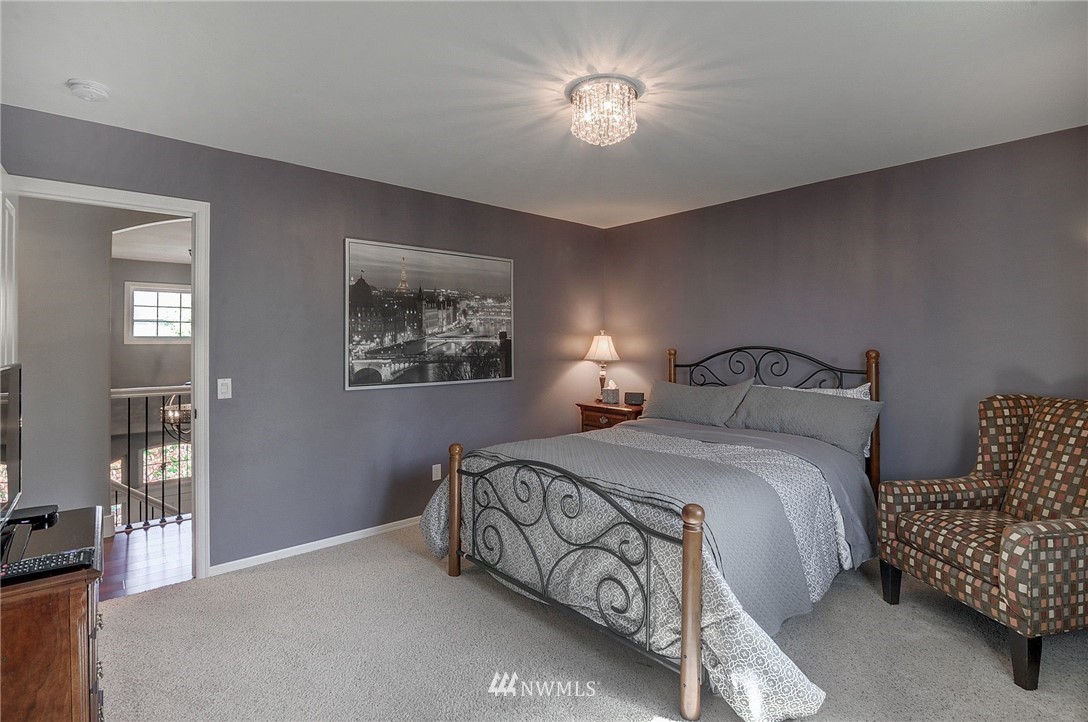 24204 21st Drive Southeast Bothell, WA 98021 - Photo 28 of 39 a bedroom with a bed and a chandelier