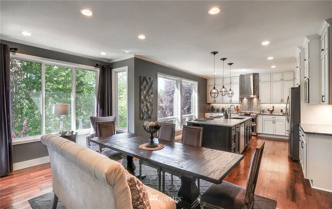 24204 21st Drive Southeast Bothell, WA 98021 - Photo 6 of 39 a open dining room with stainless steel appliances granite countertop a table chairs and a wooden floor