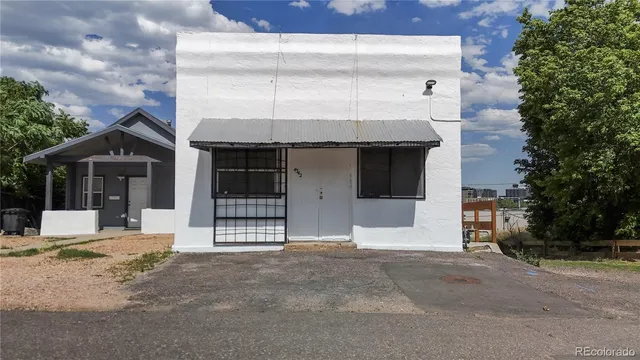 a view of an house with backyard and trees