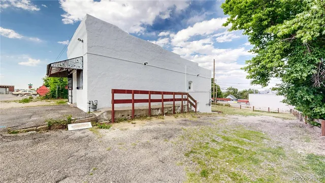 a view of a dry yard with wooden fence