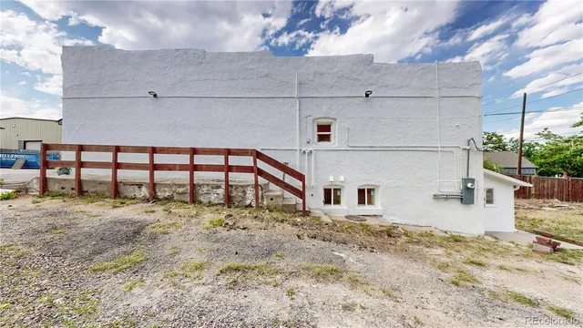 a view of a big house with wooden fence