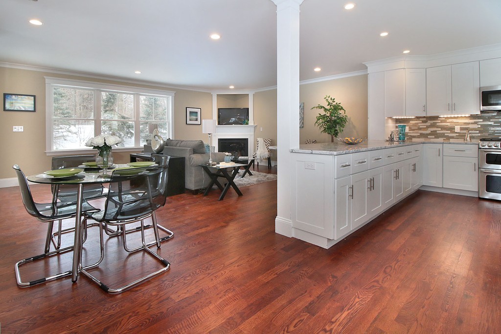 a kitchen with stainless steel appliances granite countertop wooden floors and white cabinets