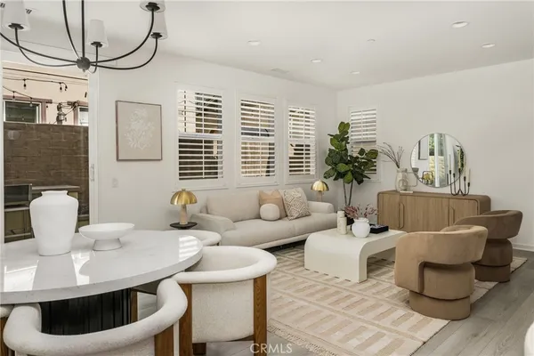 a living room with furniture potted plant and a chandelier