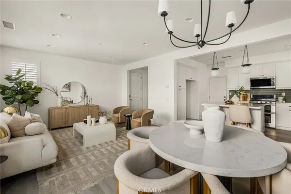 a living room with furniture a flat screen tv and a dining table