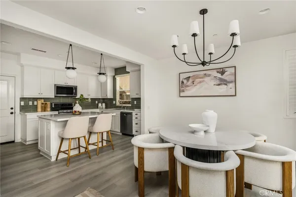 a kitchen with a refrigerator a stove a sink and dishwasher with wooden floor