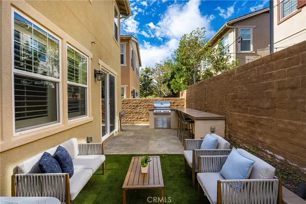 a backyard of a house with oven table and chairs