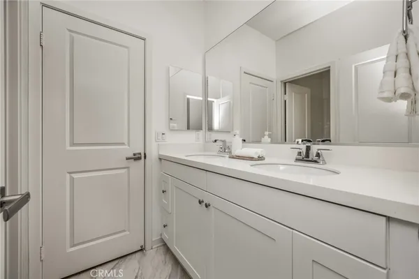 a bathroom with double sink and a mirror