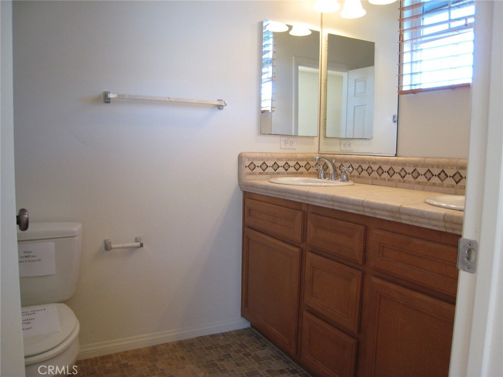 216 Dewdrop Irvine, CA 92603 - Photo 12 of 14 a bathroom with a granite countertop sink a toilet and a mirror