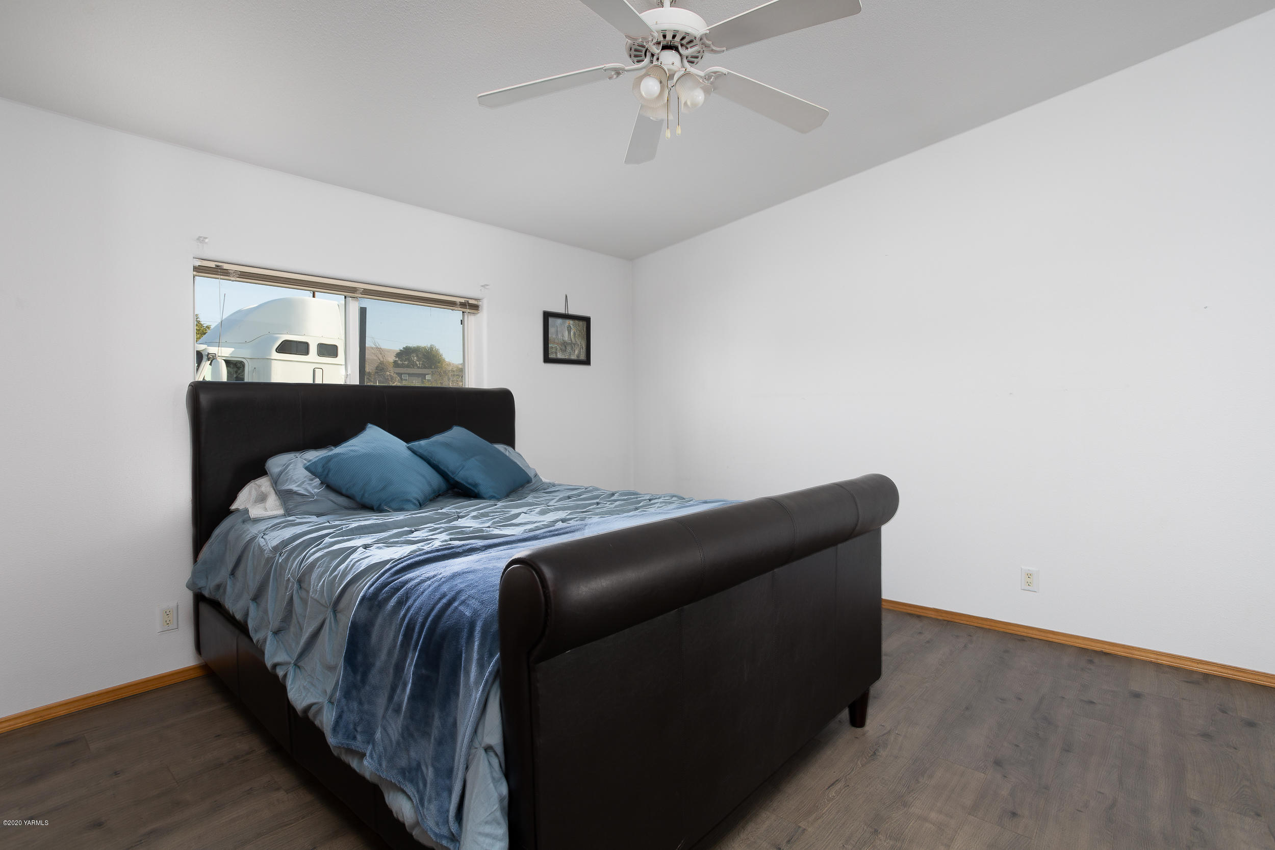 6904 Bittner Road Yakima, WA 98901 - Photo 19 of 29 a bed sitting in a bedroom next to a window with a chandelier