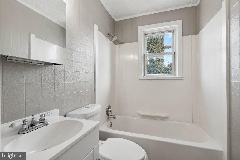 1728 Amuskai Road Baltimore, MD 21234 - Photo 20 of 30 a bathroom with a bathtub shower sink vanity and toilet