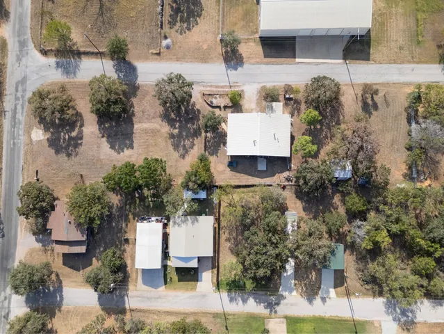 an aerial view of a house with a yard and large trees