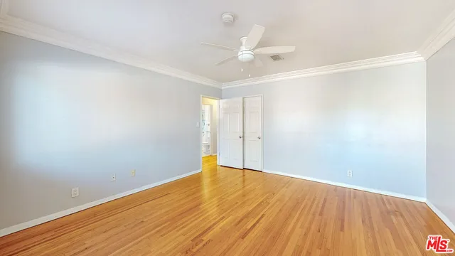 a view of an empty room with wooden floor