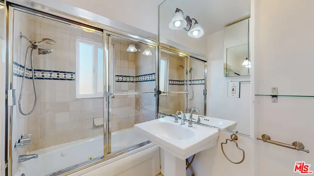 a bathroom with a shower sink and mirror