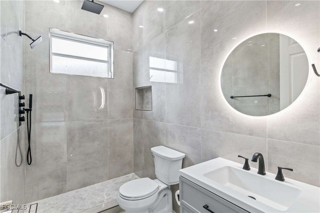 221 Old Burnt Store Road South Cape Coral, FL 33991 - Photo 30 of 49 a bathroom with a sink a toilet and a mirror