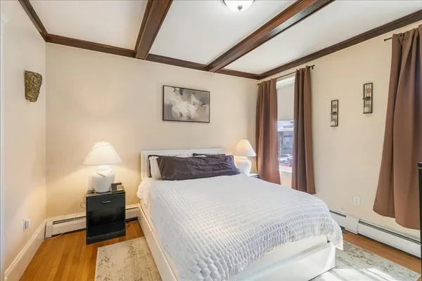 a bedroom with a bed and a lamp with wooden floor