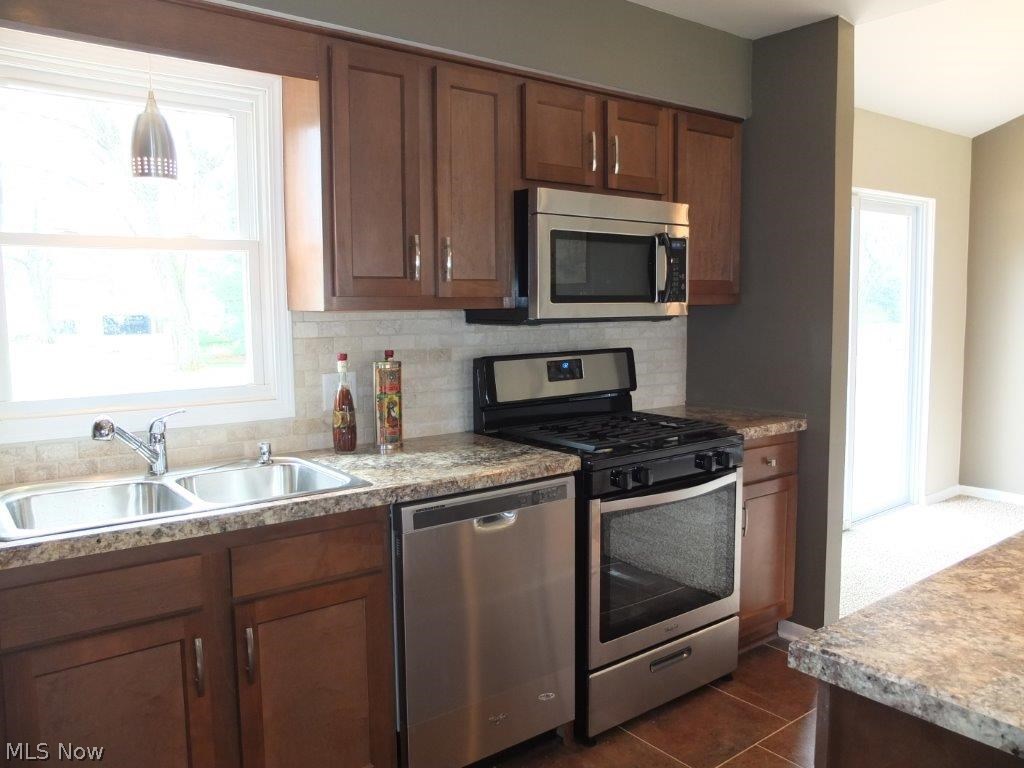 3352 Brenner Road Barberton, OH 44203 - Photo 5 of 16 Kitchen comes applianced with stainless steel dishwasher, gas range, oven and over the range microwave.