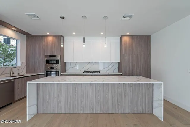 a view of a kitchen with kitchen island a sink wooden floor and a counter top space