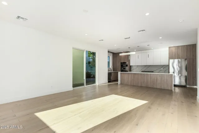 a view of a kitchen with refrigerator and windows