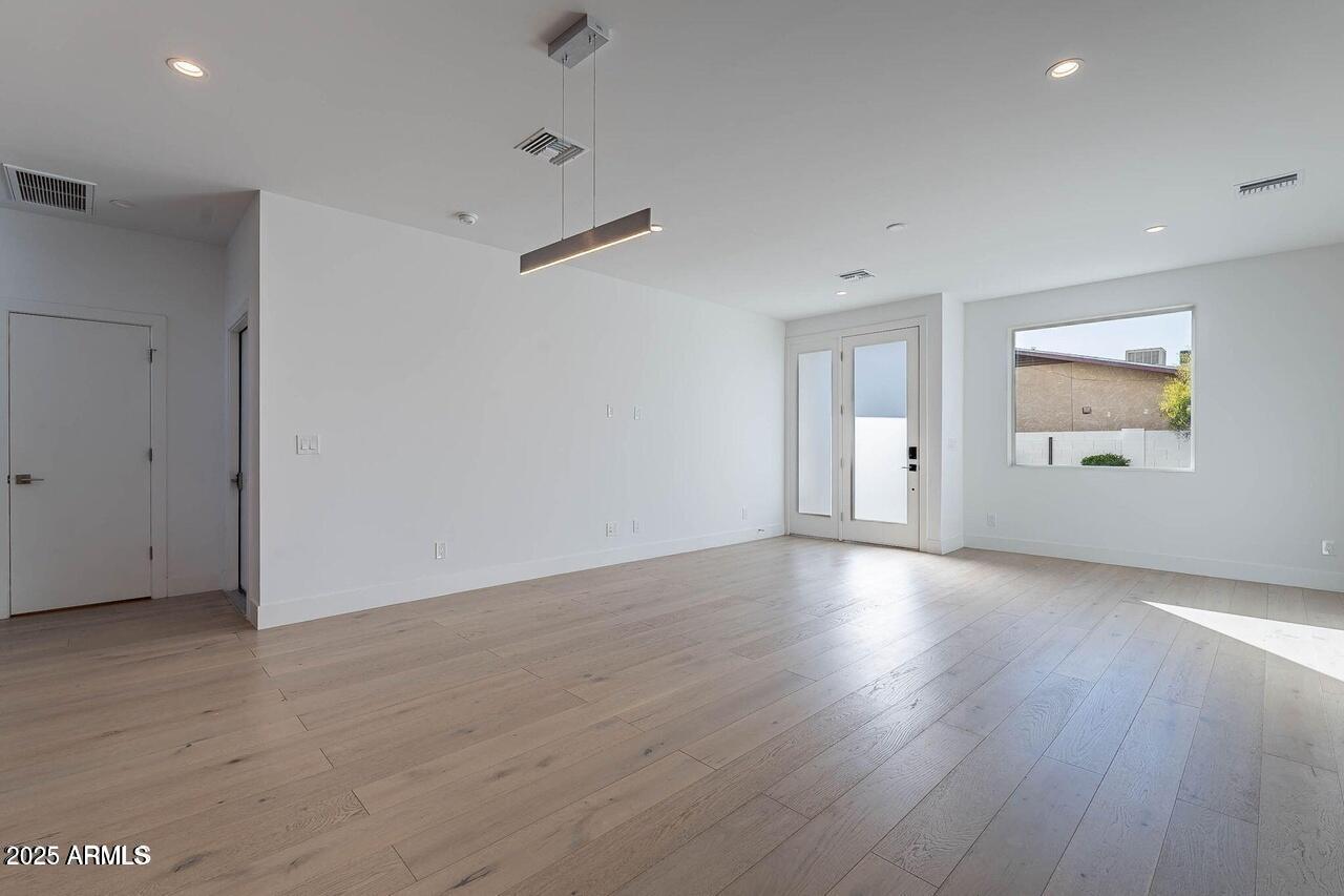 2130 East Turney Avenue, Unit 4 Phoenix, AZ 85016 - Photo 4 of 15 a view of an empty room with wooden floor and a window