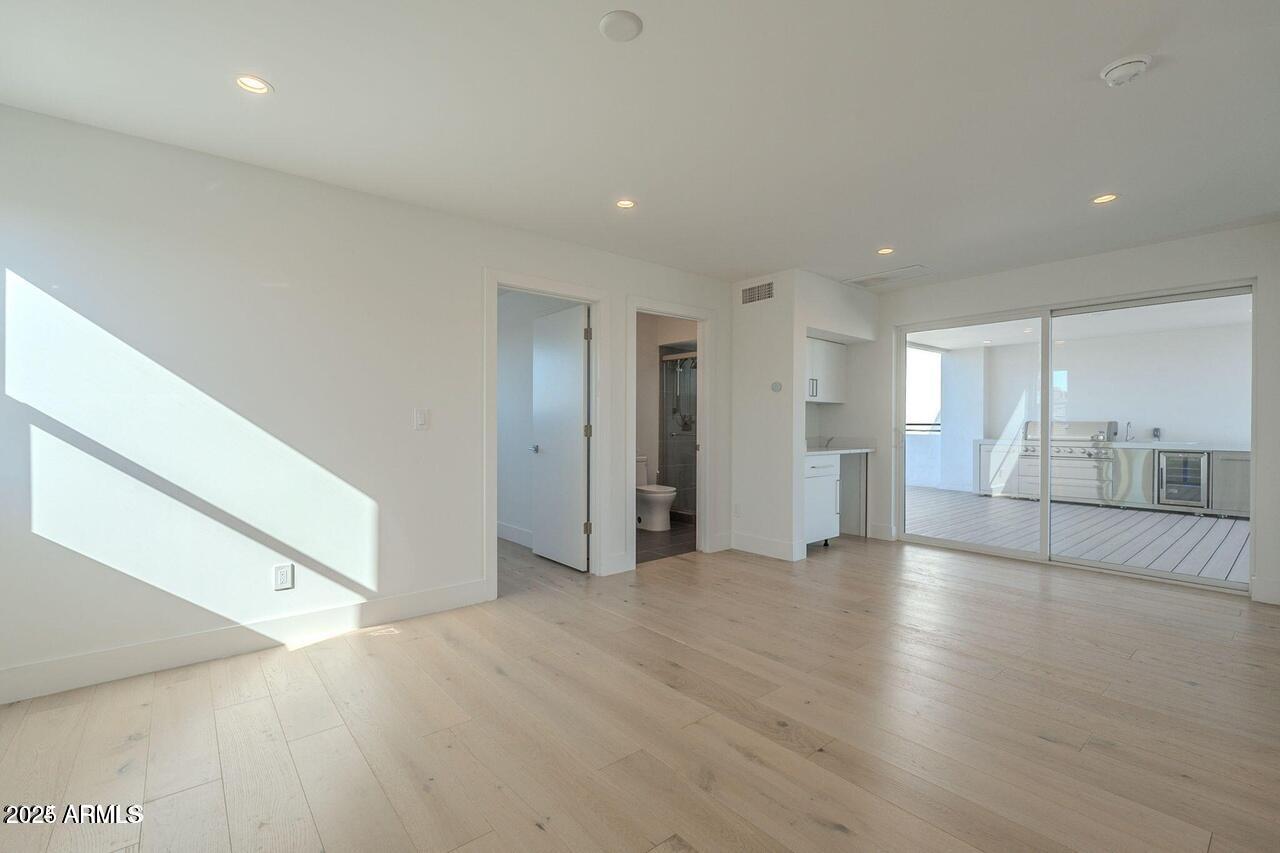 2130 East Turney Avenue, Unit 4 Phoenix, AZ 85016 - Photo 9 of 15 an empty room with wooden floor and windows