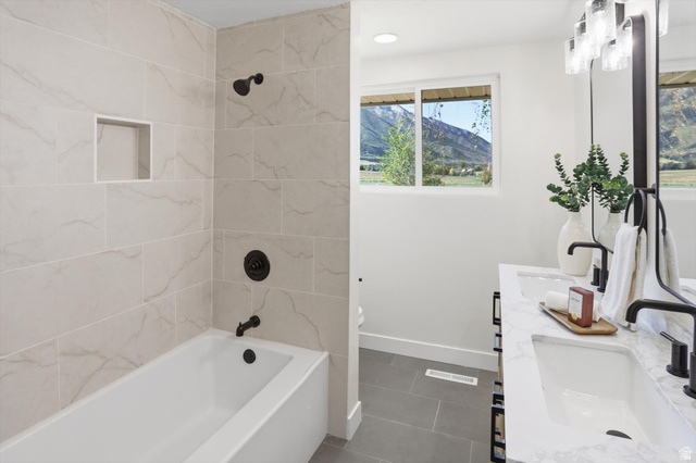 810 East Maple Street Mapleton, UT 84664 - Photo 19 of 49 Bathroom featuring a built-in tub with a tiled surround, recessed shower niche, and matte black fixtures