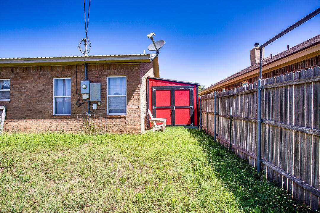 905 11th Street Wolfforth, TX 79382 - Photo 17 of 18 a view of a backyard with brick wall and potted plants