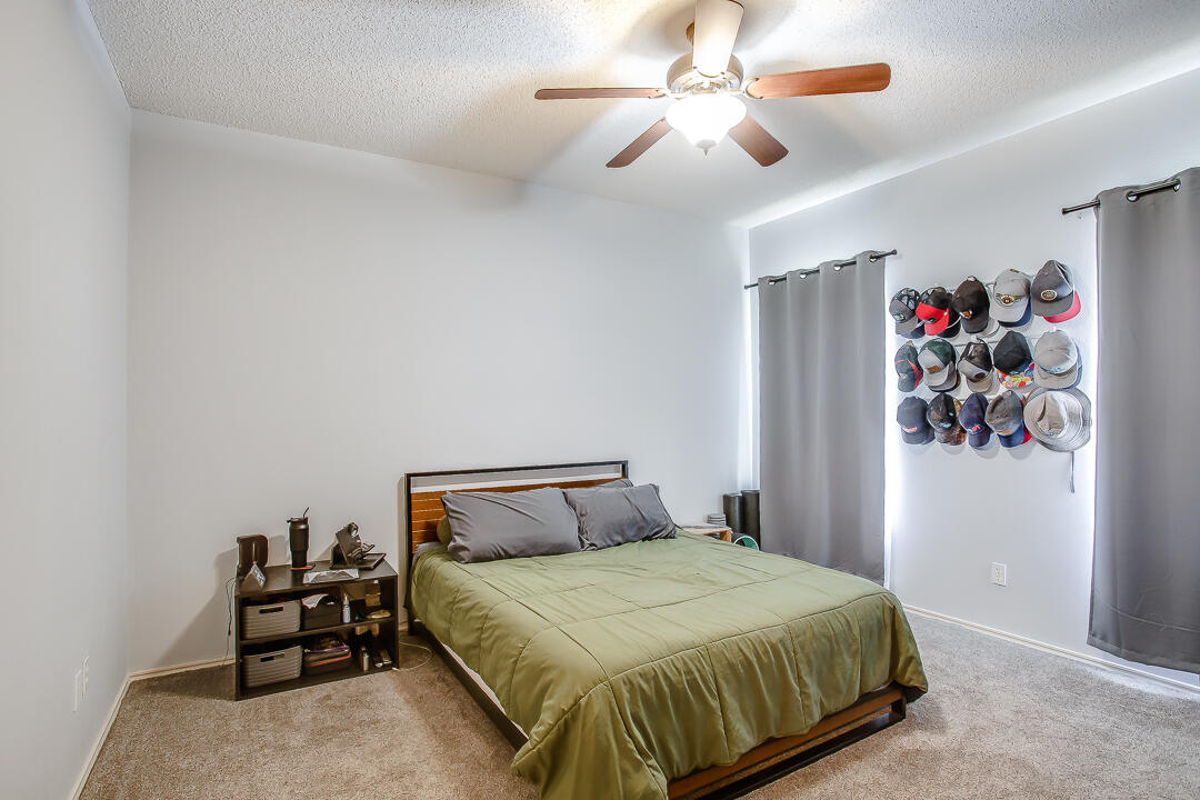 905 11th Street Wolfforth, TX 79382 - Photo 9 of 18 a bedroom with a bed and a chandelier