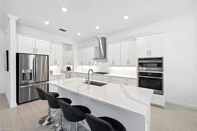 a kitchen with stainless steel appliances granite countertop a sink refrigerator and cabinets