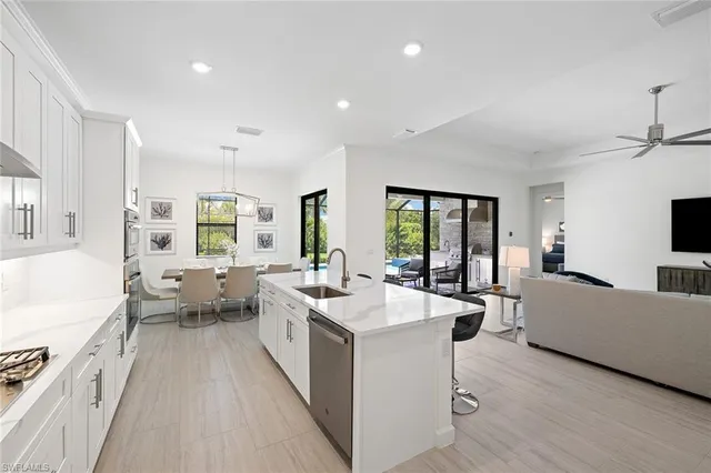 a large room with kitchen island a white cabinets and wooden floor
