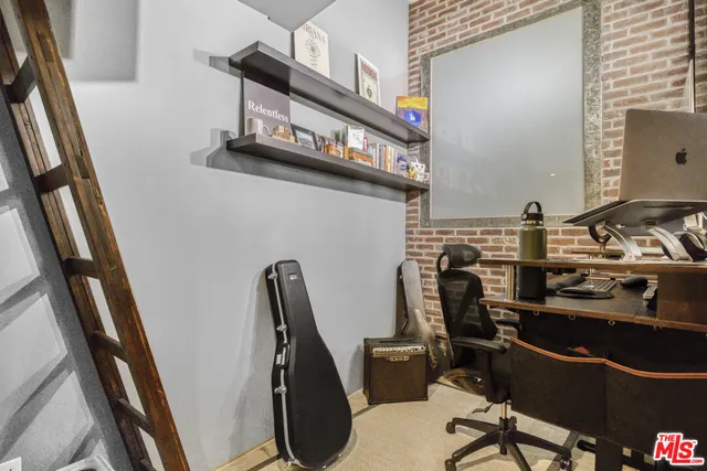 a view of a workspace with furniture and a window