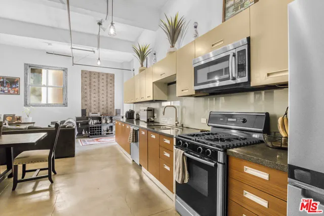 a kitchen with stainless steel appliances a stove a sink dishwasher and cabinets with wooden floor